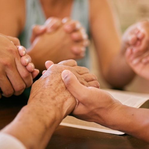 Shot of a group of people holding hands in prayer Shot of a group of people holding hands in prayer