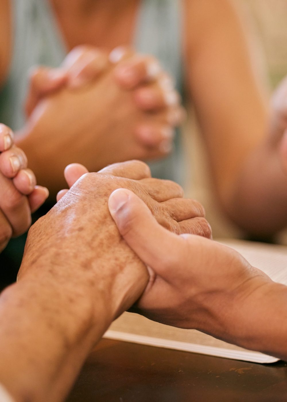 Shot of a group of people holding hands in prayer